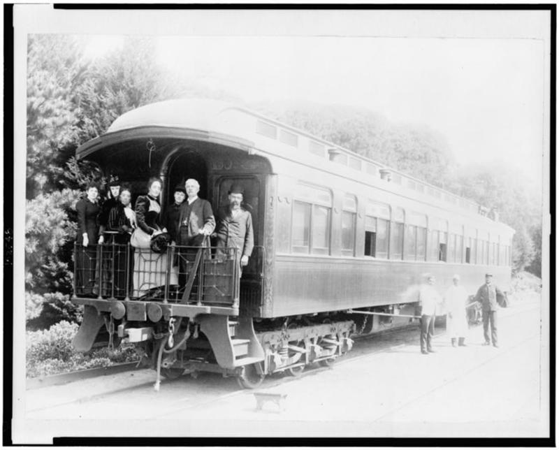 "Henry M. Stanley and party standing on back of train at Monterey, California, March 19th, porters standing at side of car."